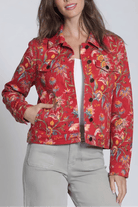 Woman wearing a red floral jacket against a white background