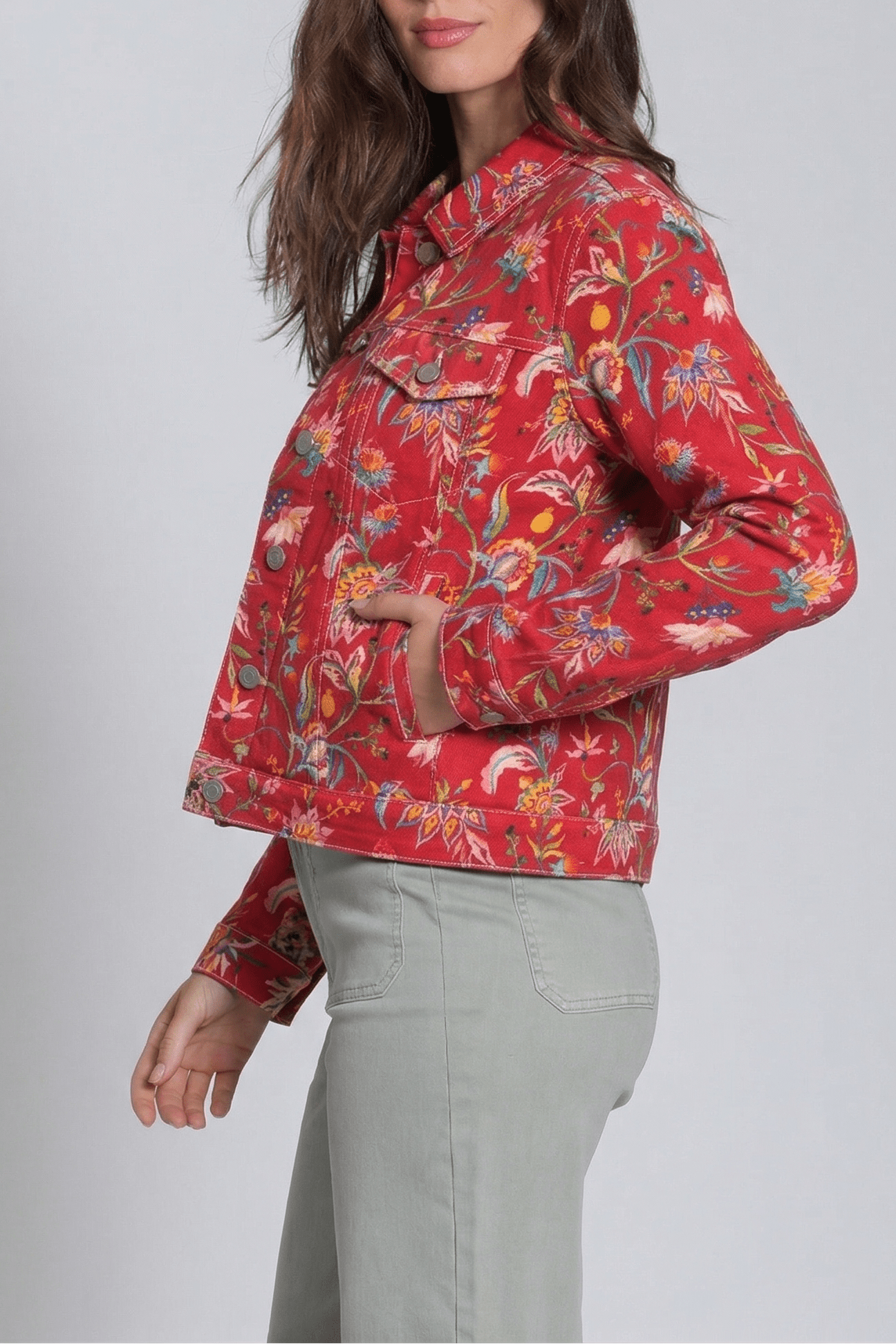 Woman wearing a red floral jacket on a gray background