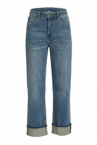 Indigo jeans with rolled-up cuffs on a white background