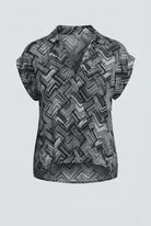 Black and white patterned sleeveless top on a light gray background