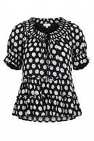 Black blouse with white polka dot pattern on a white background
