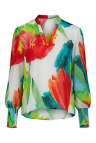 Colorful floral blouse with red, green, and blue flowers on a white background