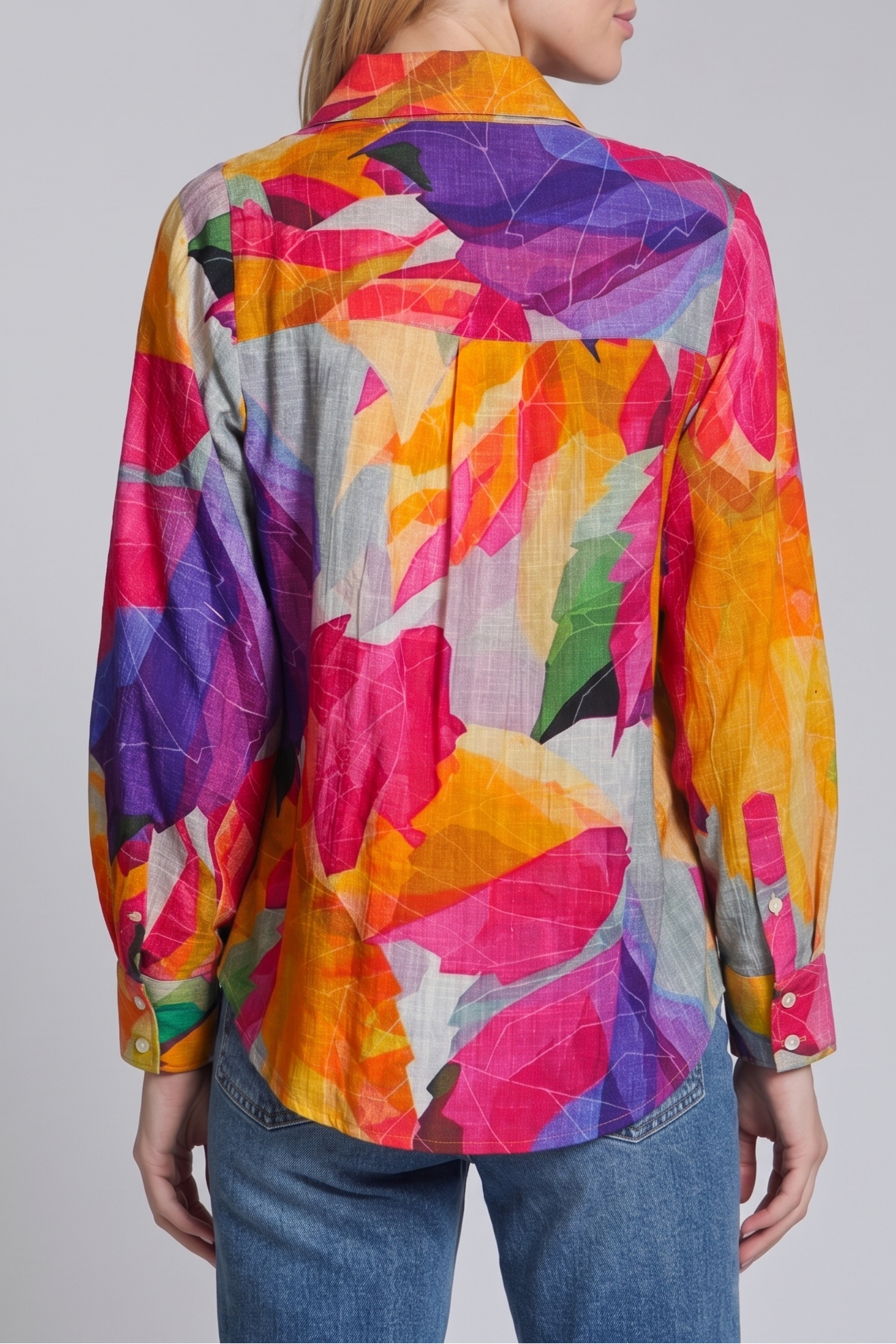 Woman wearing a colorful patterned shirt on a plain background