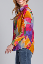 Woman wearing a colorful patterned shirt against a gray background